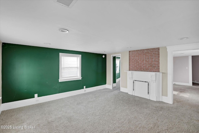 unfurnished living room with carpet floors, visible vents, a fireplace, and baseboards