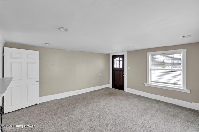 entrance foyer featuring carpet and baseboards