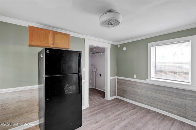 kitchen with ornamental molding, light wood-style flooring, and freestanding refrigerator