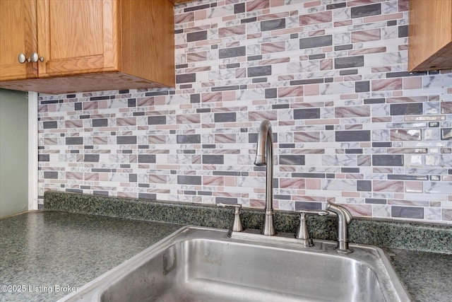 details featuring dark countertops, a sink, and decorative backsplash