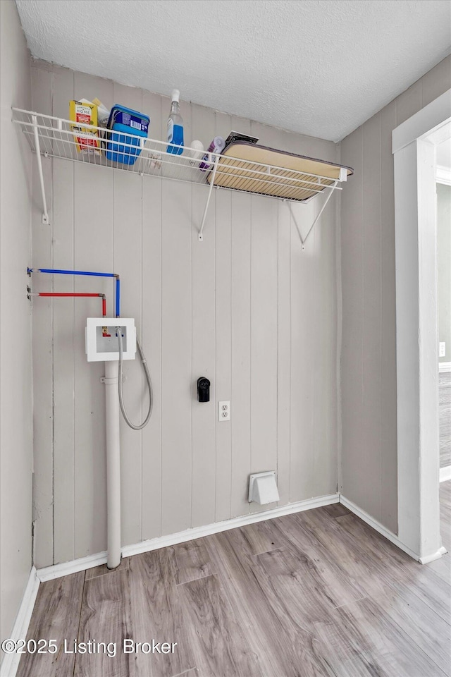 washroom with a textured ceiling, laundry area, wood finished floors, and hookup for a washing machine