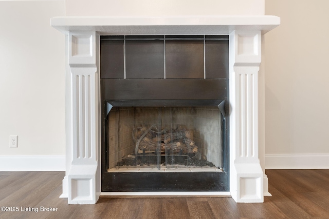 room details with a fireplace, baseboards, and wood finished floors