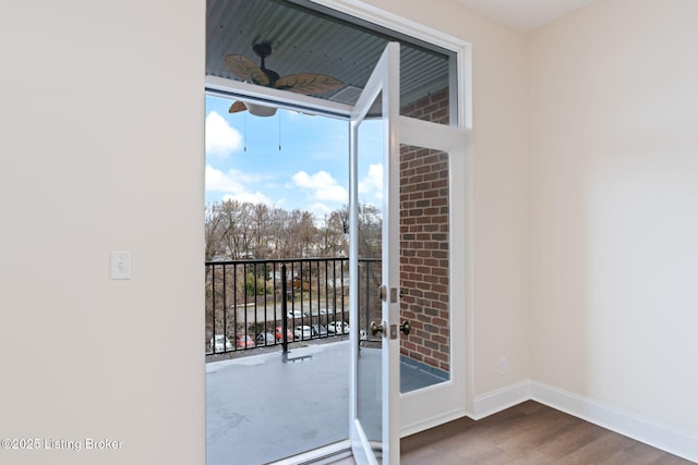 doorway with baseboards and wood finished floors