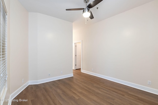 unfurnished room with ceiling fan, baseboards, and dark wood-type flooring