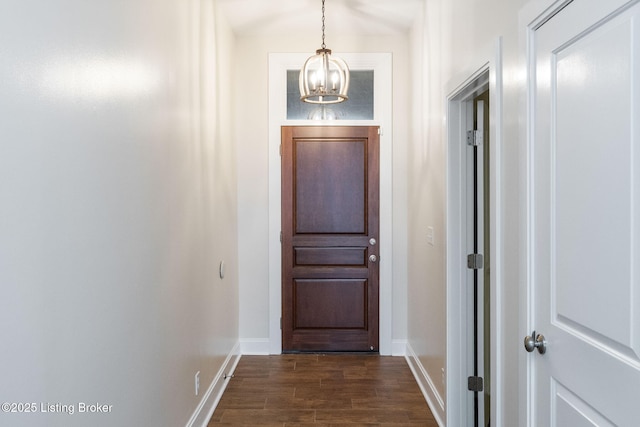 entryway with an inviting chandelier, baseboards, and dark wood finished floors