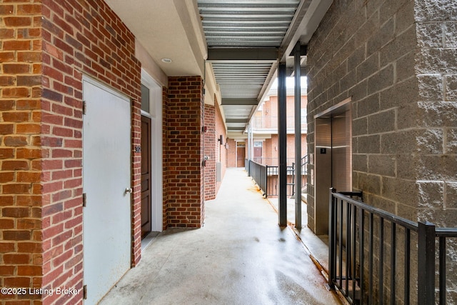 hallway with concrete floors and elevator