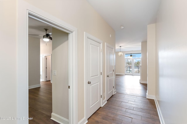 hall featuring dark wood-style floors and baseboards