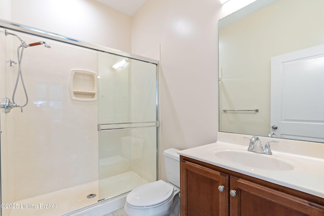 bathroom with toilet, a shower stall, and vanity