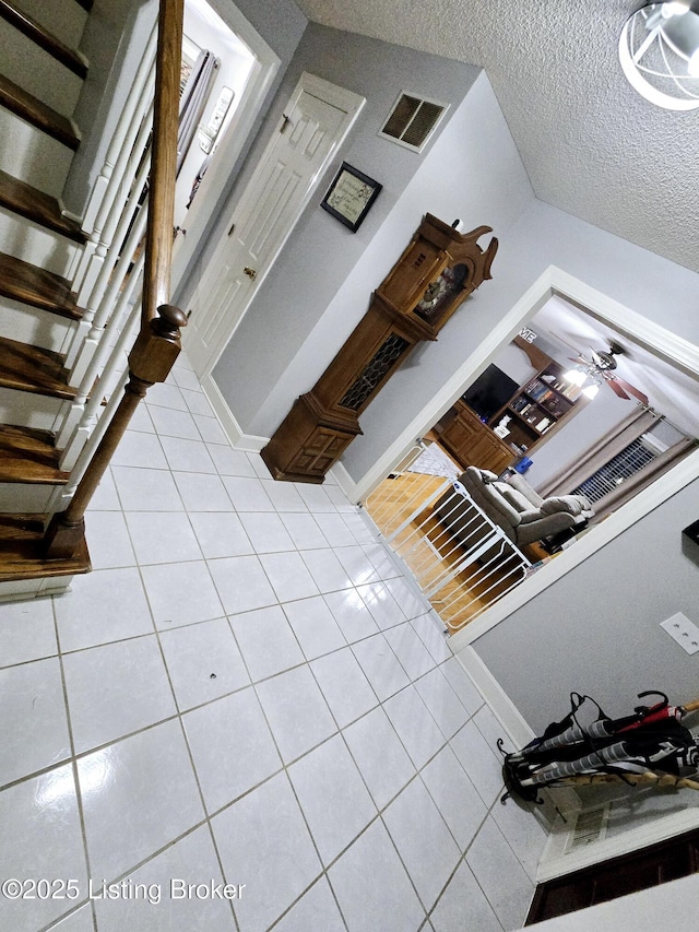 interior space with stairs, a textured ceiling, and visible vents