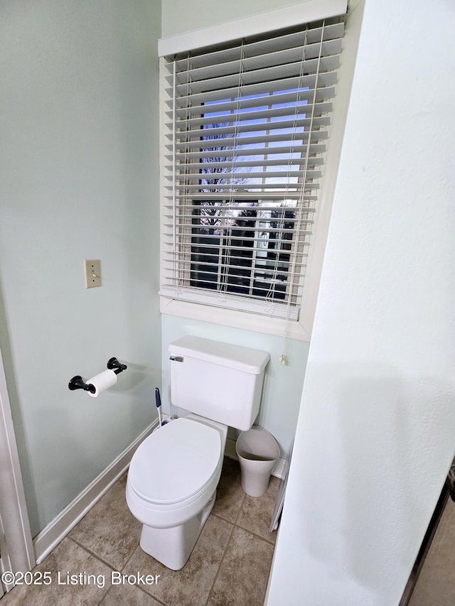 bathroom with toilet, tile patterned flooring, and baseboards