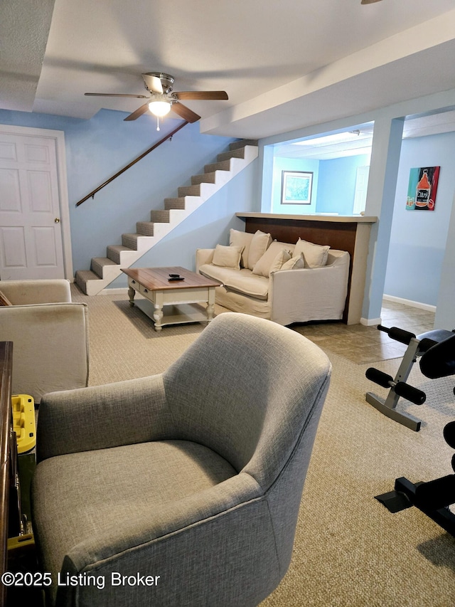 living area featuring carpet, ceiling fan, stairway, and baseboards