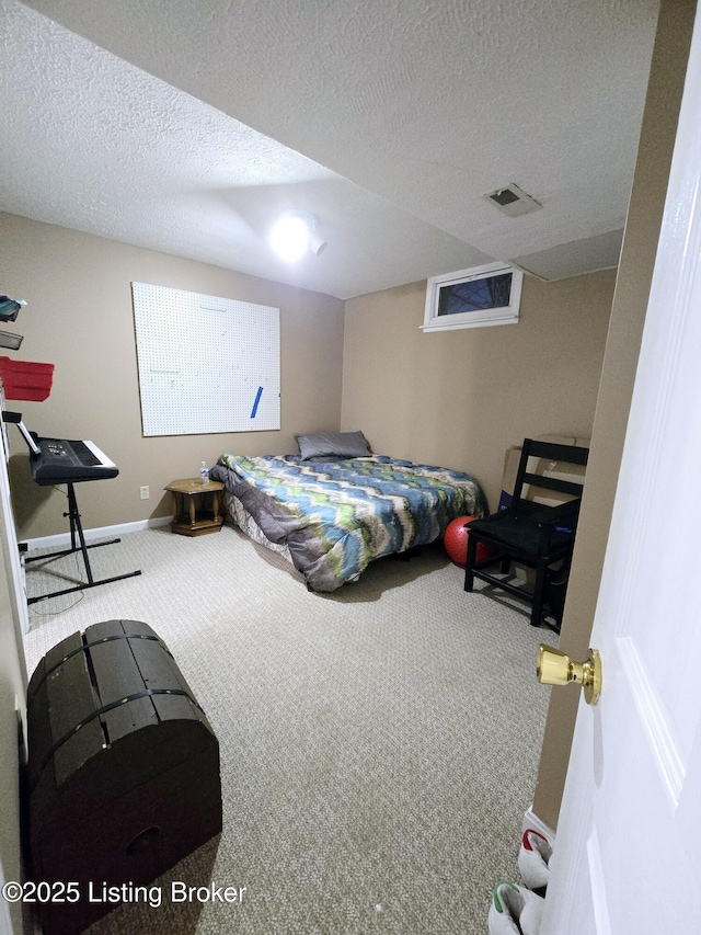 carpeted bedroom featuring baseboards, visible vents, and a textured ceiling