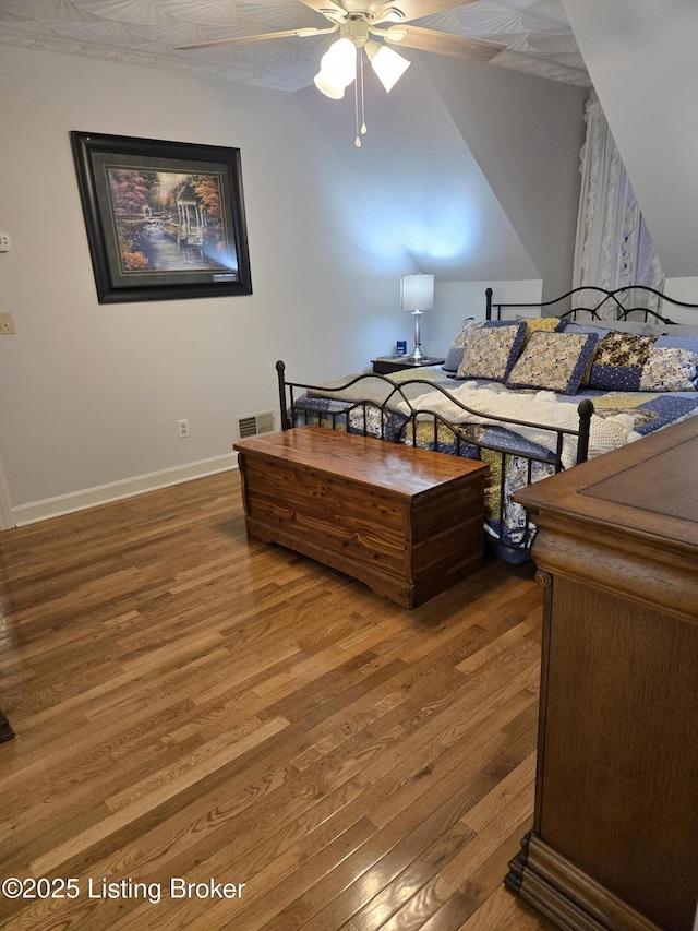 bedroom featuring wood finished floors, visible vents, and baseboards