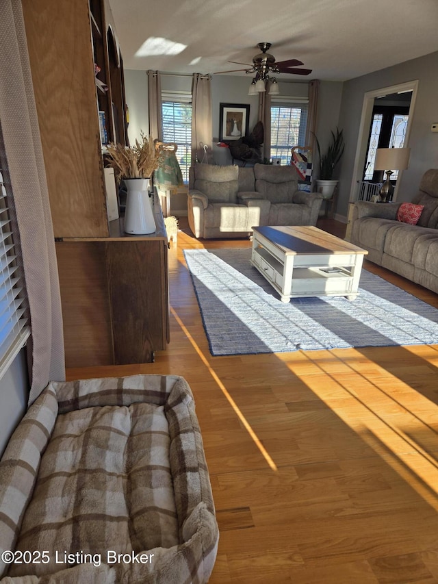 unfurnished living room featuring a ceiling fan, a healthy amount of sunlight, and wood finished floors