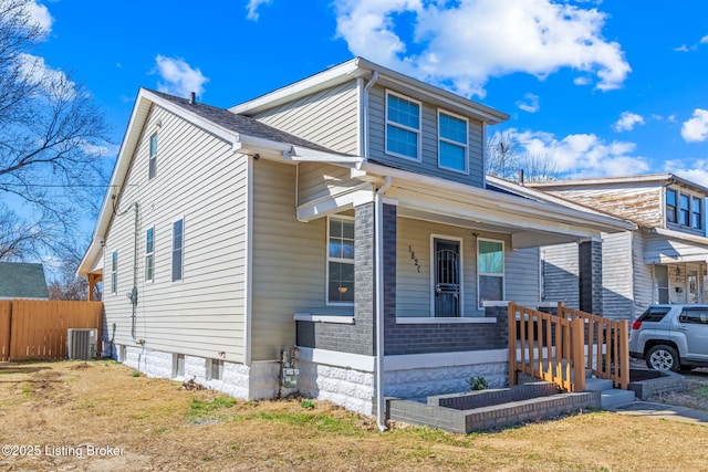 bungalow-style house featuring fence, central AC unit, and covered porch