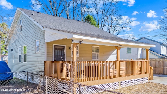 view of front of home with fence and roof with shingles