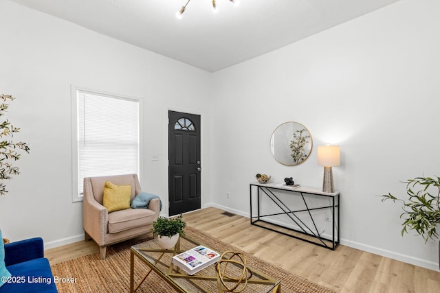 living area featuring baseboards and wood finished floors