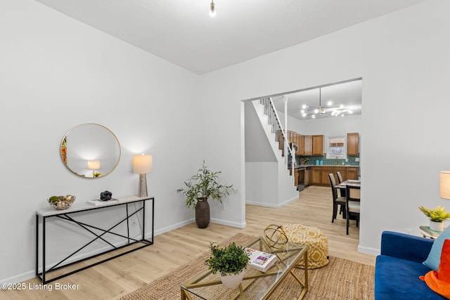 living room featuring baseboards, stairs, and light wood finished floors