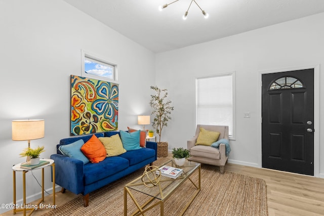 living area featuring wood finished floors, baseboards, and a chandelier