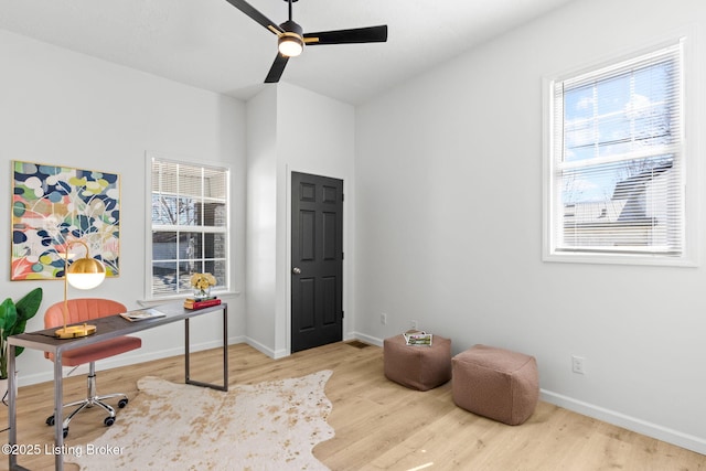 office space featuring a ceiling fan, wood finished floors, and baseboards