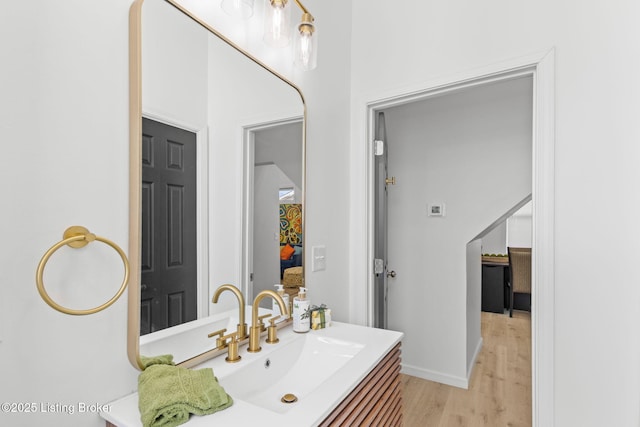 bathroom featuring baseboards, wood finished floors, and vanity