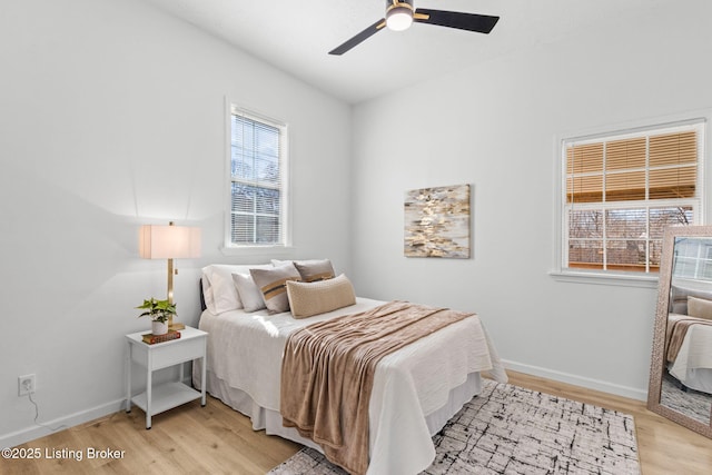 bedroom with baseboards, ceiling fan, and light wood finished floors