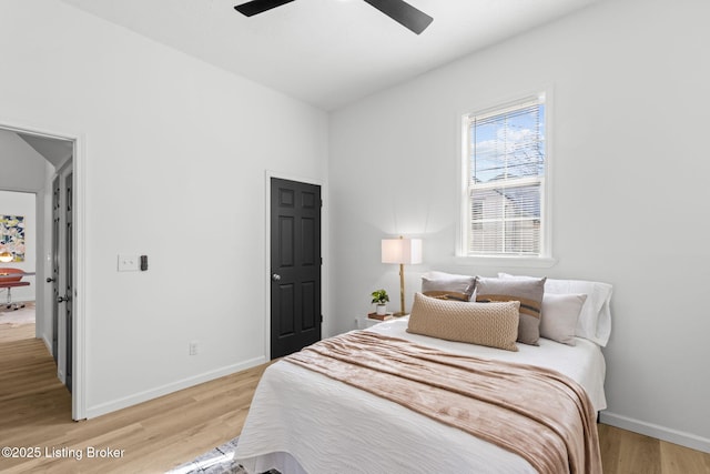 bedroom featuring light wood-style flooring, a ceiling fan, and baseboards