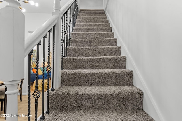 stairway with baseboards and wood finished floors