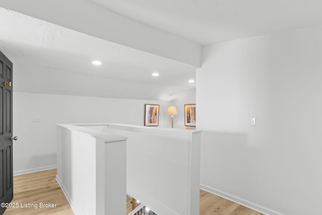 hallway featuring recessed lighting, light wood-type flooring, an upstairs landing, and baseboards