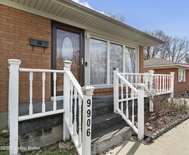 view of exterior entry with brick siding