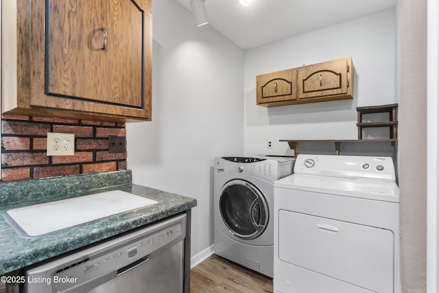 laundry room featuring light wood-style floors, cabinet space, a sink, and washer and clothes dryer