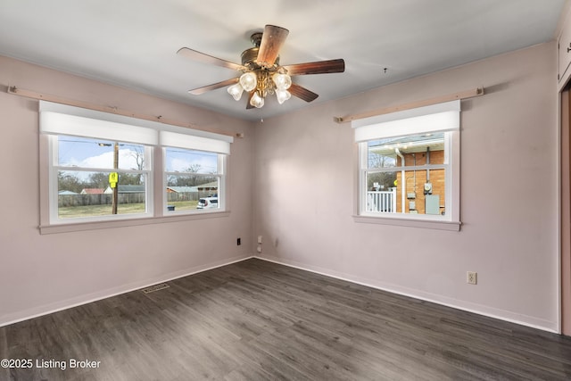 unfurnished room featuring ceiling fan, baseboards, visible vents, and dark wood finished floors