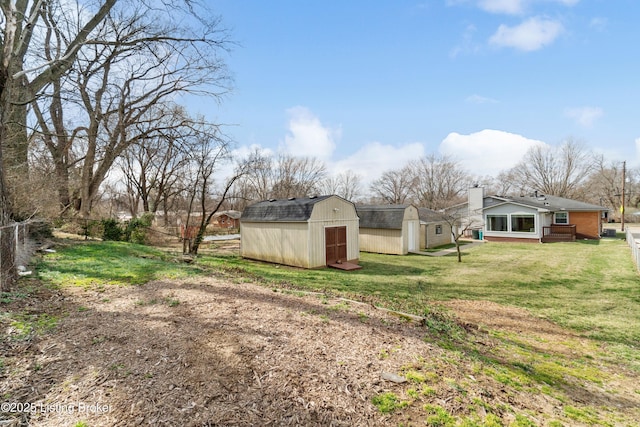 view of yard featuring an outbuilding, a shed, and fence