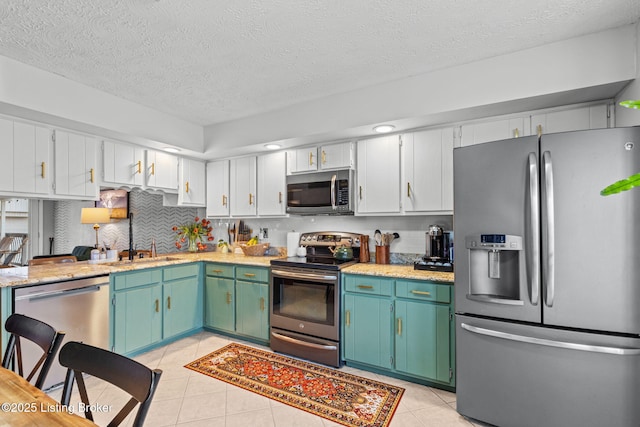 kitchen with light tile patterned floors, tasteful backsplash, appliances with stainless steel finishes, and a sink