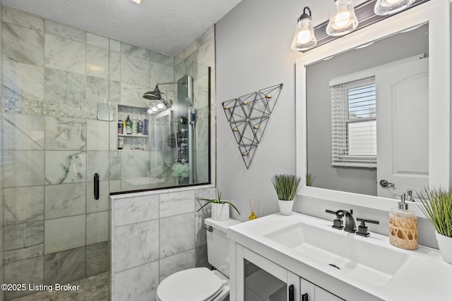 bathroom featuring a stall shower, a textured ceiling, toilet, and vanity