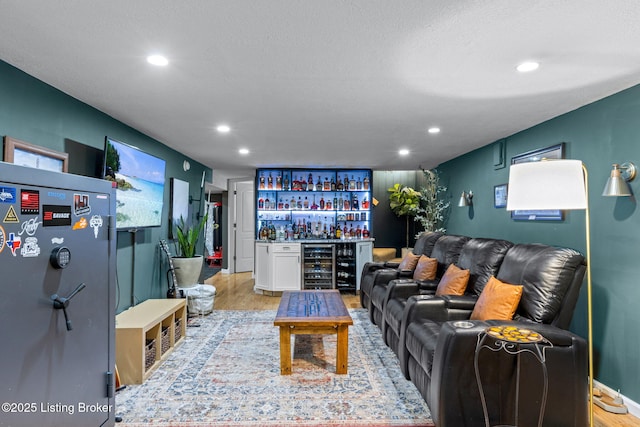 living room featuring a dry bar, light wood-type flooring, beverage cooler, and recessed lighting