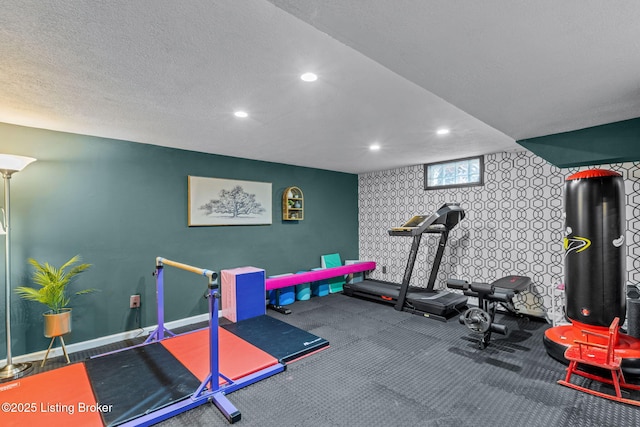 exercise room with baseboards, a textured ceiling, and recessed lighting