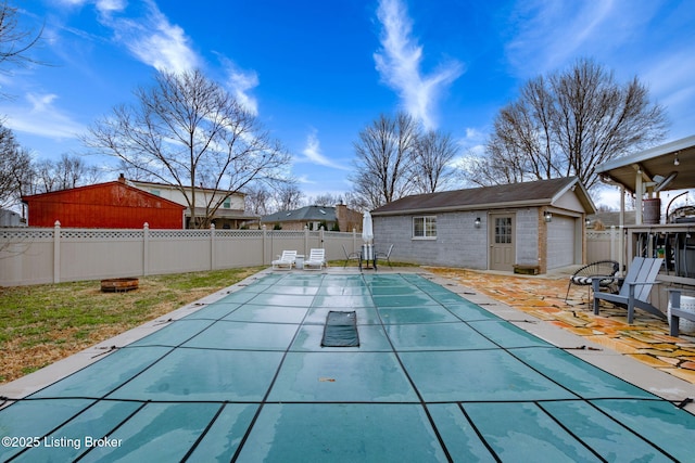 view of pool with an outbuilding, a patio, a fenced backyard, and a fenced in pool