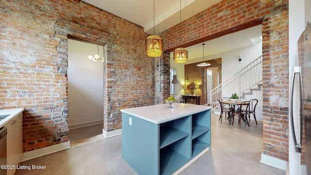 kitchen featuring finished concrete flooring, a towering ceiling, brick wall, appliances with stainless steel finishes, and open shelves