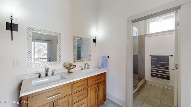 bathroom featuring double vanity, tile patterned flooring, a sink, and tiled shower