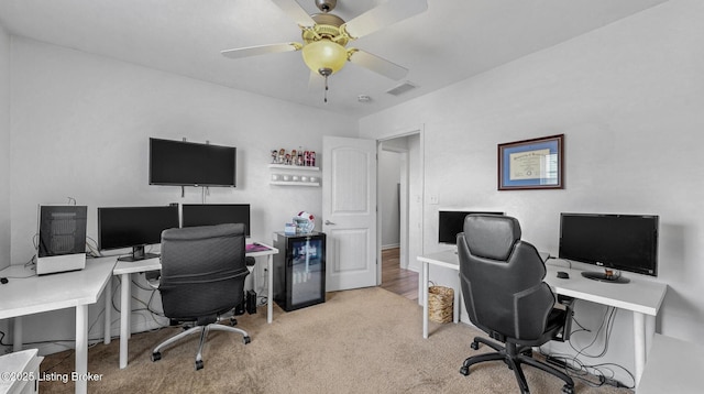 office space with a ceiling fan, visible vents, and carpet floors