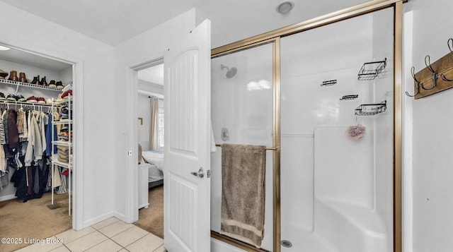 full bath with a spacious closet, a shower stall, and tile patterned floors