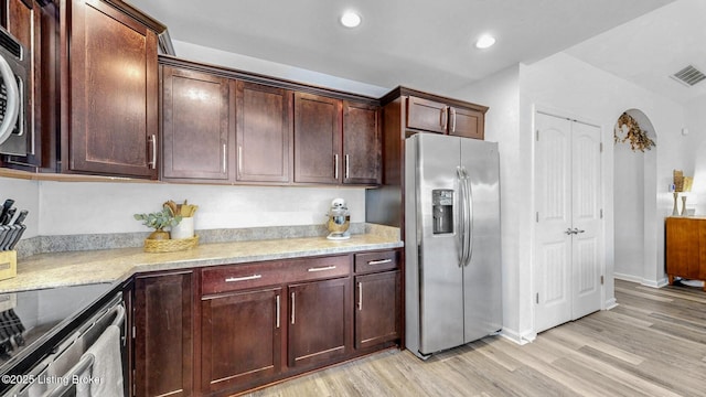 kitchen with arched walkways, light wood-style flooring, recessed lighting, visible vents, and appliances with stainless steel finishes