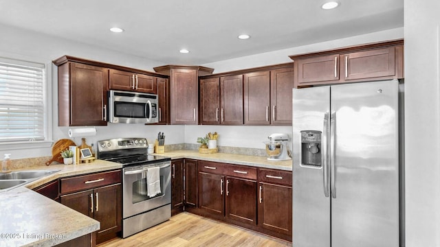 kitchen featuring light wood-style floors, stainless steel appliances, light countertops, and recessed lighting