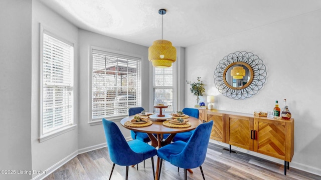 dining space with baseboards and light wood-style floors