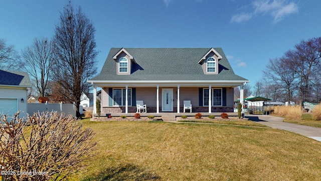 cape cod home with a front yard, fence, driveway, covered porch, and stone siding