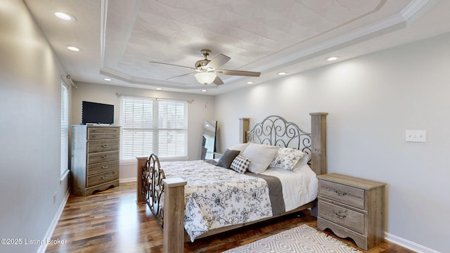 bedroom with dark wood-type flooring, baseboards, a tray ceiling, recessed lighting, and a ceiling fan