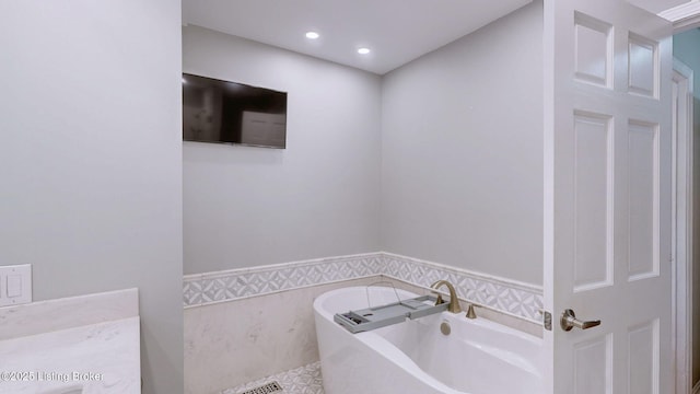 full bathroom featuring recessed lighting, a freestanding bath, tile walls, and wainscoting