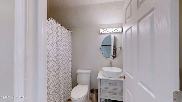 bathroom featuring toilet, a textured ceiling, vanity, and curtained shower