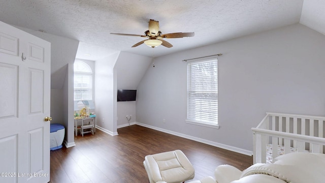 bedroom featuring lofted ceiling, wood finished floors, baseboards, and a textured ceiling